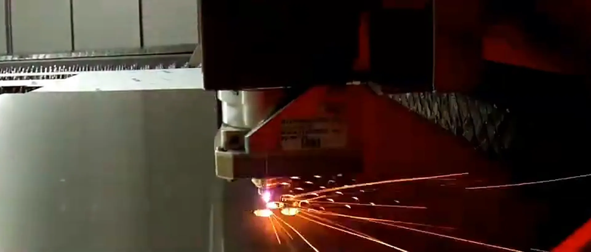 Laserschneidkopf mit Funkenflug beim Schneiden von Blech
